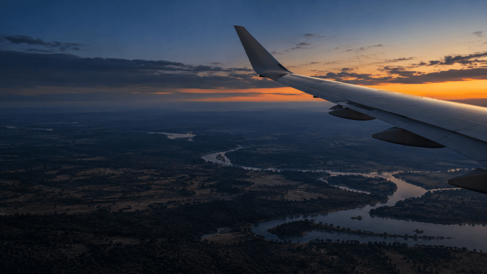 Passenger aircraft flying above clouds at sunset